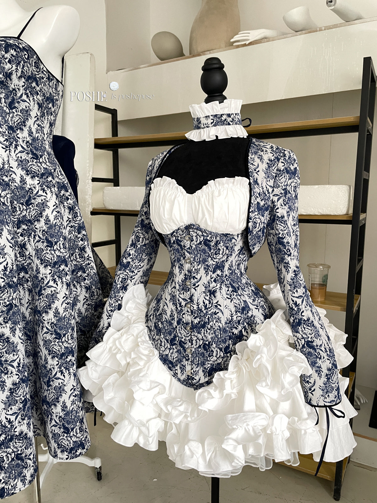Poshepose Rococo corset dress with blue floral embroidery and ruffled white skirt.
