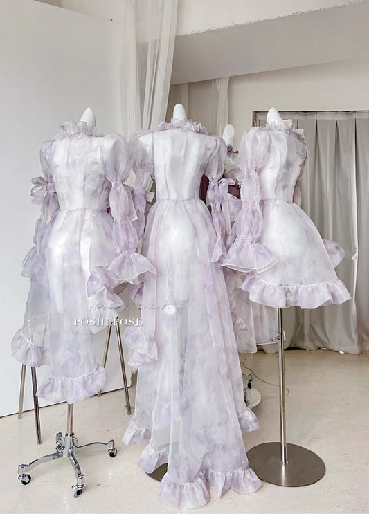 Romantic fairycore cape dress in soft lavender tones with oversized bow and cascading layers.