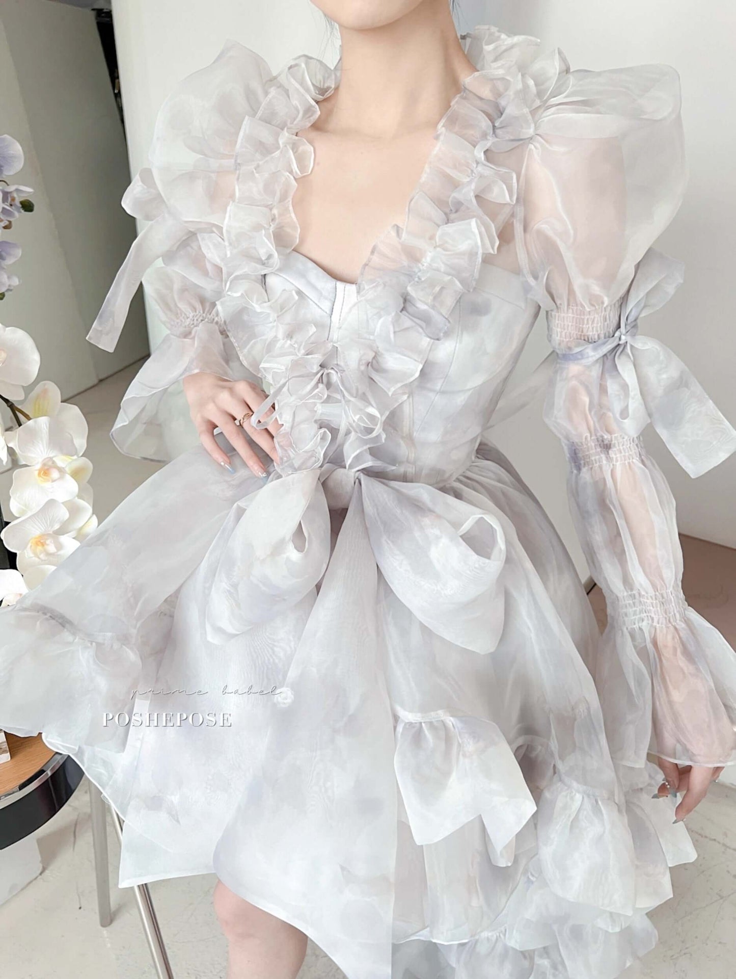 Luxury pastel organza cape dress with corset bodice and puffed sleeves.