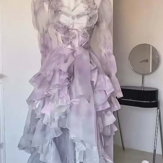 Luxury lilac pastel dress featuring layered ruffles and transparent cape overlay.