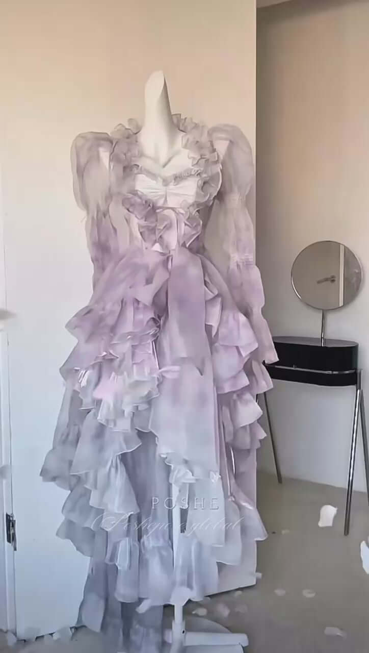 Luxury lilac pastel dress featuring layered ruffles and transparent cape overlay.