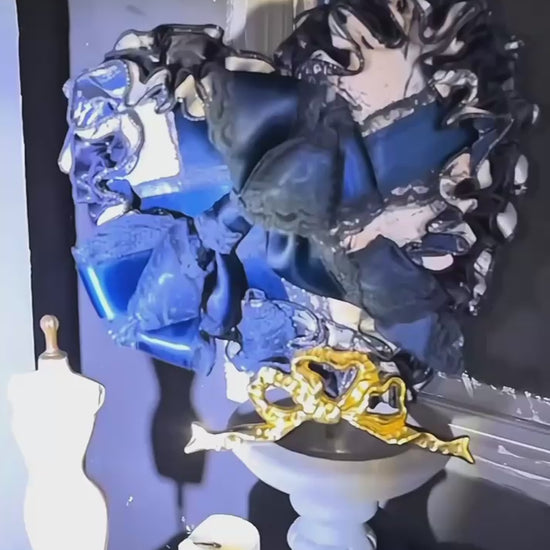 Baroque-inspired navy corset dress with puff sleeves and ruffled underskirt.